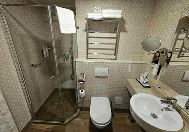 Wellton Hotels bathroom: functional, dated tiling, hotel room renovation, corporate event venue.