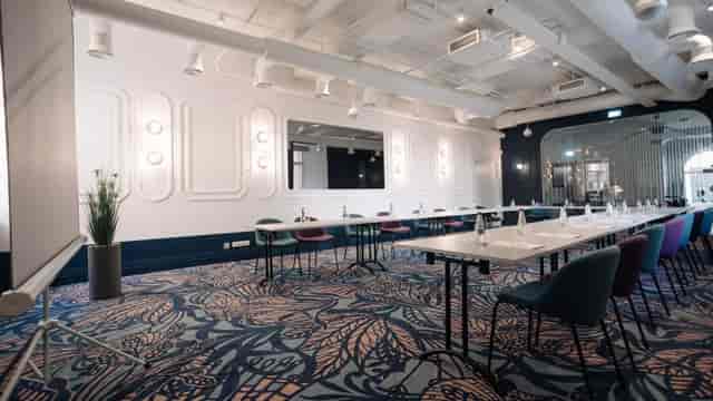 U-shaped meeting room with patterned carpet for corporate workshops and board meetings.