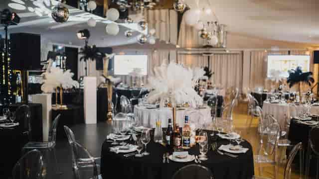 Art Deco gala banquet room with ostrich feather centerpieces for luxury events and conferences.