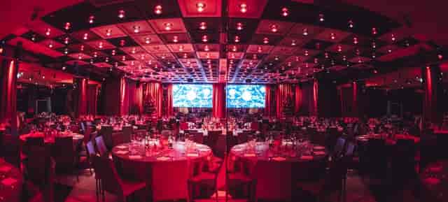 Pestalozzi Hall ballroom with red lighting for corporate gala and awards ceremony.
