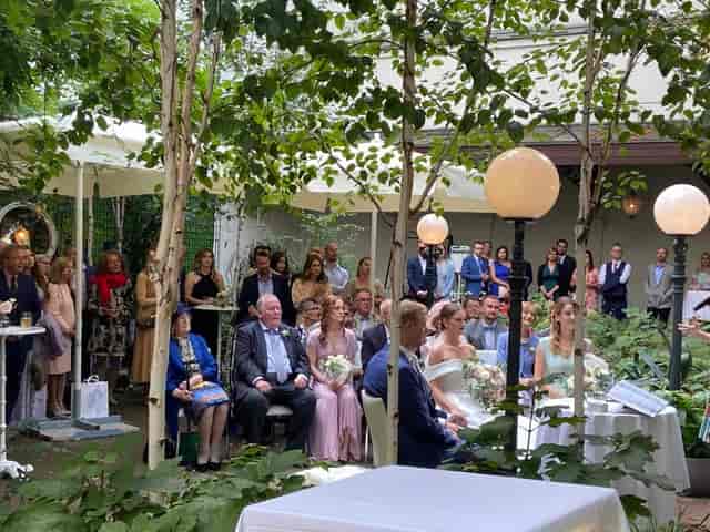 Outdoor wedding ceremony at VIENNABallhaus terrace with garden seating for elegant event planning.