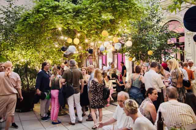 String-lit Vienna Ballhaus terrace, intimate networking event venue with hanging paper lanterns.