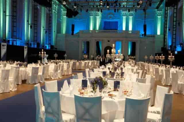 Elegant gala banquet hall in Halle E+G with white linens and dramatic uplighting for formal events.