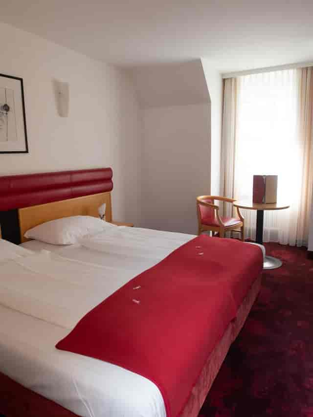 Standard hotel room with workspace for business travelers, neutral decor, and modern design.