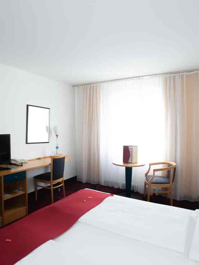 Hotel Boltzmann guest room with workspace, ideal for business travel and corporate conferences.