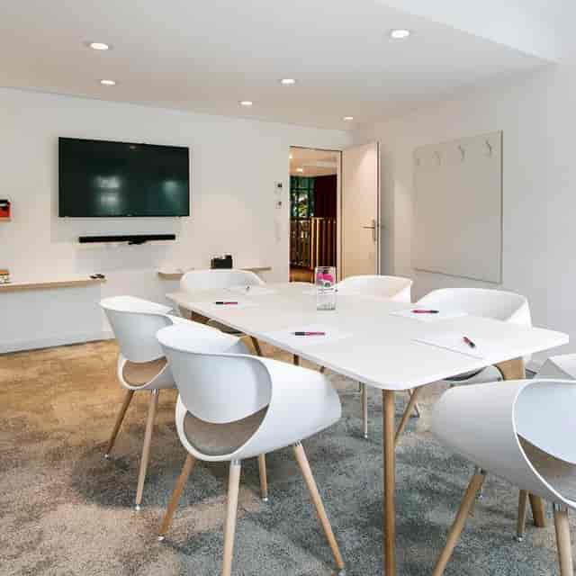 Minimalist boardroom with AV technology for corporate meetings and breakout sessions.