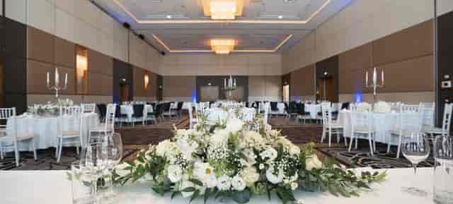 Hilton Vienna Waterfront ballroom with floral centerpieces for corporate events and wedding galas.