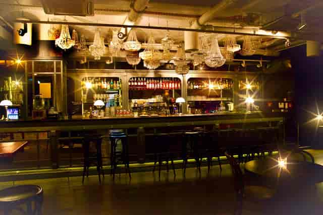 Industrial-chic event space with cluster chandeliers for corporate cocktail and networking events.