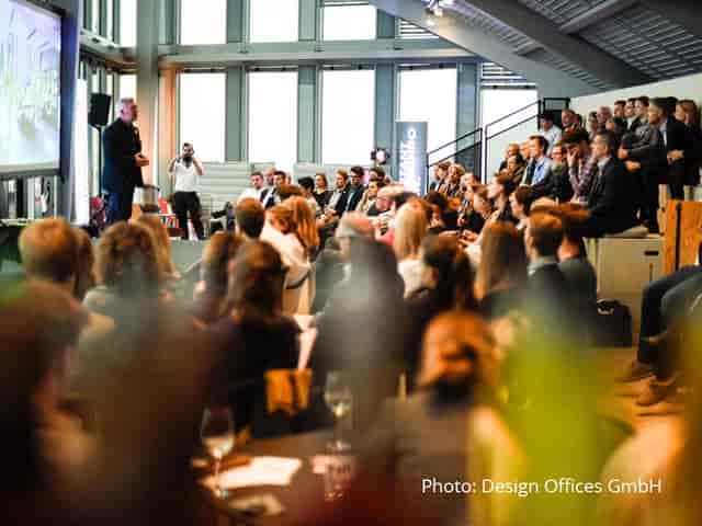 Corporate presentation at Encore Vienna featuring tiered seating for modern business conferences.