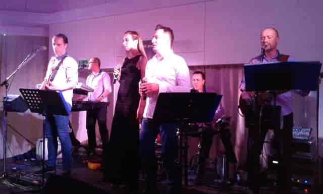 Live band performing in White Palace hall for gala or corporate mixer event.