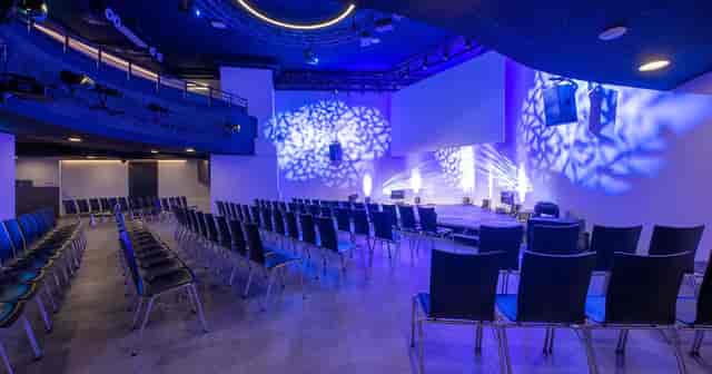Modern corporate event space with theater seating for professional keynotes and product launches.