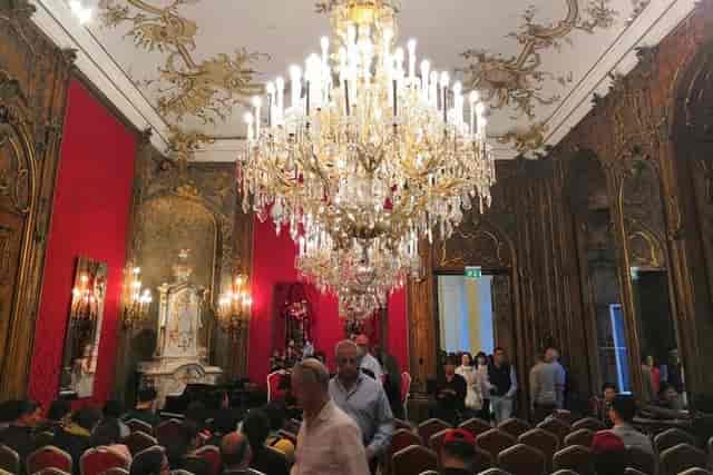 Red Salon event space with opulent chandelier for luxury gala and historic reception venue.