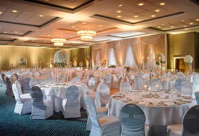 Ballroom event space with round tables and floral centerpieces for gala or wedding venue hire.