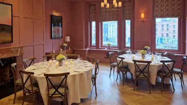 Private dining room at The Clarence with dusty-rose panels for upscale events and board meetings.