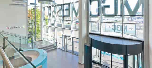 Modern MGC Messe venue foyer with curved reception desk for corporate events and trade shows.