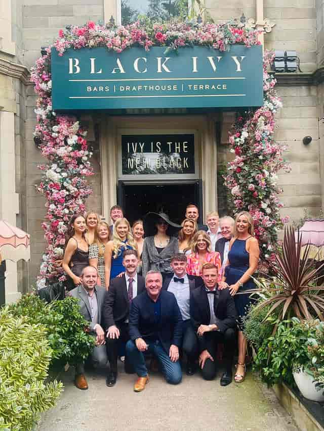 Black Ivy cocktail bar entrance with floral decor for event branding and Instagrammable parties.