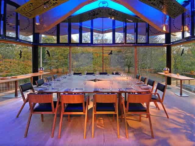 Modern glass conference room with forest views for board meetings and private dining events.