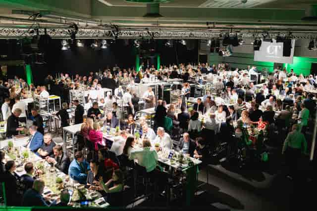 Networking event in QEII Centre with attendees at high tables, elegant atmosphere.