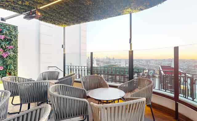 Chic outdoor VIP event space at Hotel Riu Plaza España with panoramic sunset views.