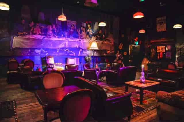 "Eclectic event space with leather seating and mural, ideal for intimate gatherings."