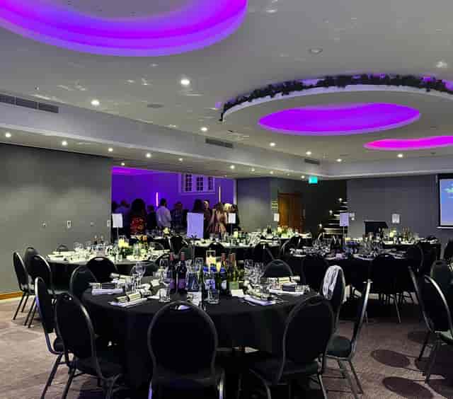 Elegant event space at The York, featuring black tablecloths and purple lighting for corporate dinners.