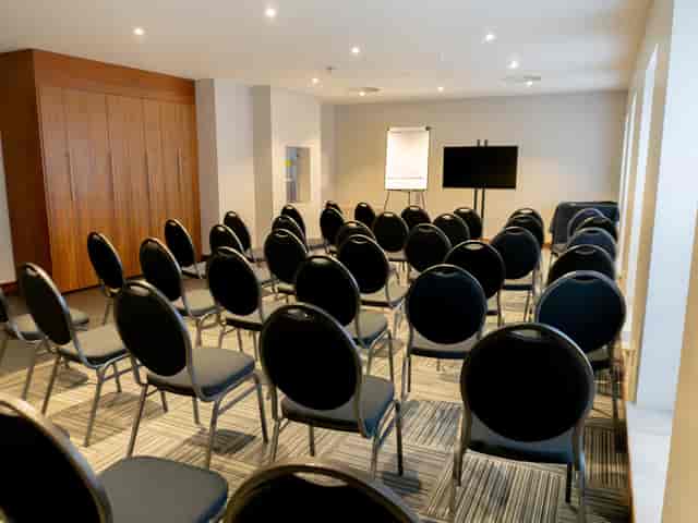 Meeting room at The Baird, featuring black chairs for workshops and presentations.