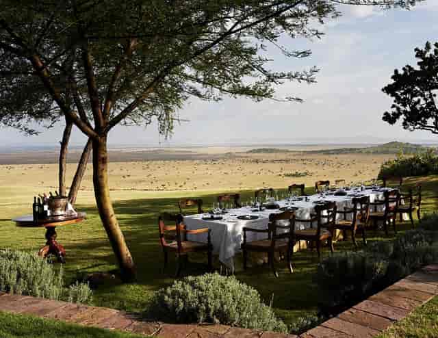 Luxury open-air banquet setup in Masai Mara for exclusive incentive dinners and experiential events.