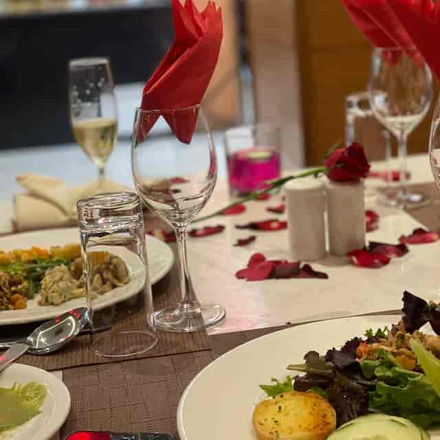 Romantic table setting at Kinaya bar with rose petals for anniversary or proposal events.