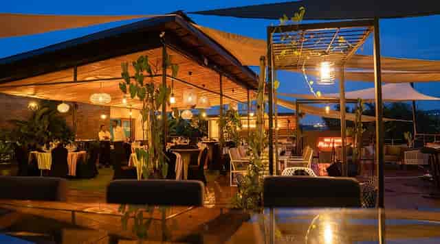 Rooftop restaurant with lush greenery for corporate mixer and evening reception events.