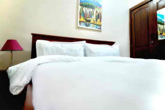 Hotel room in Sixsixty Apartments, Dar es Salaam with wooden headboard for business travel.