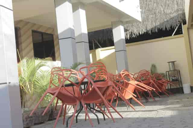 Outdoor lounge bar at Mambosasa View Hotel, Sinza: event setup area with stacked chairs.
