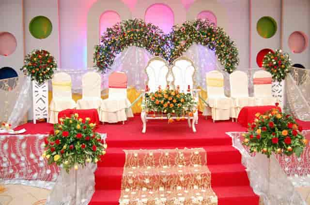 Traditional wedding stage with floral arches at Msimbazi Centre reception hall.