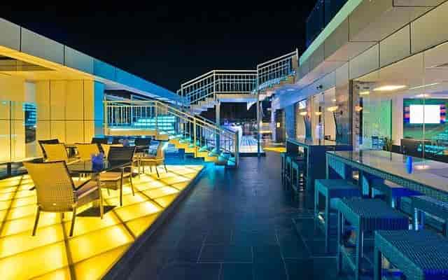 Rooftop bar & grill with illuminated floor for corporate cocktail receptions and networking events.
