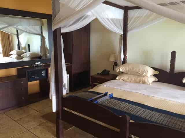 Four-poster canopy bed suite at Kigoma Hilltop Hotel for luxury incentive travel and VIP lodging.