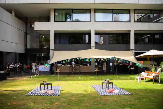 Outdoor summer event at RCP London with a large tent and stylish seating.