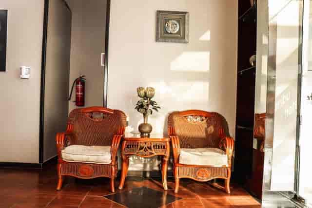 Worn hotel foyer with wicker furniture: budget venue for business meetings and corporate events.