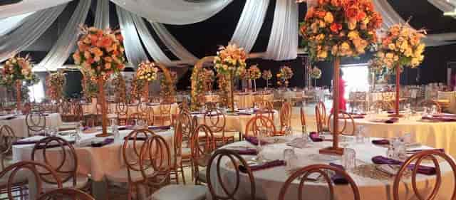 Luxury marquee wedding reception with floral centerpieces and gold-frame chairs at La Madison Place.