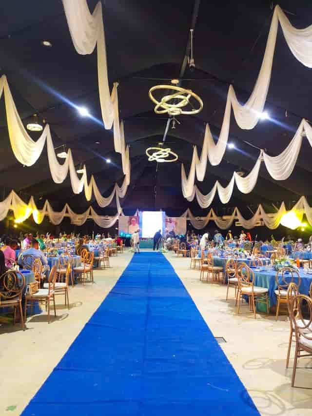 Marquee event venue with royal blue carpet and gold banquet seating for formal wedding or gala.
