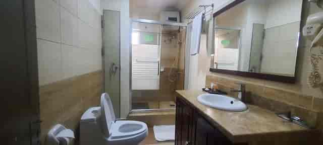 Standard hotel bathroom with dated fixtures, ideal for hospitality renovation and facility audits.