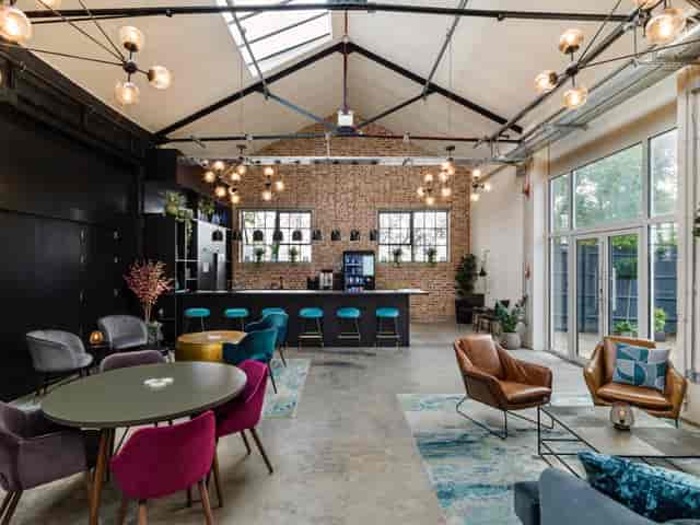Modern lounge-style podcast room with exposed brick, ideal for corporate gatherings and events.