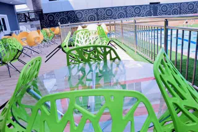 Mambillah Hotel outdoor pool-deck cocktail event space with modern glass-top tables.