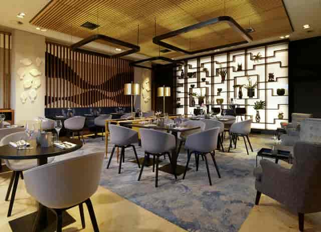 Modern, sunlit VIP lounge at Pillars Bar & Kitchen for corporate networking and business meetings.