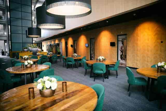 Modern Hotel Rotterdam banquet room with round tables for corporate events and networking.