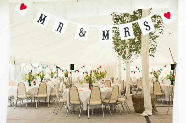 Rustic-chic marquee wedding tent at Kenton Hall Estate with DIY bunting decor.