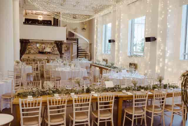 Elegant Oh Me Oh My event venue with farmhouse tables and string lights for corporate gatherings.