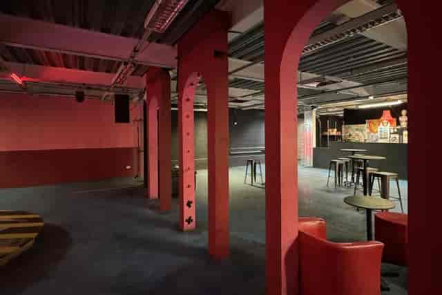Industrial event space with red arches: venue for evening receptions and networking mixers.