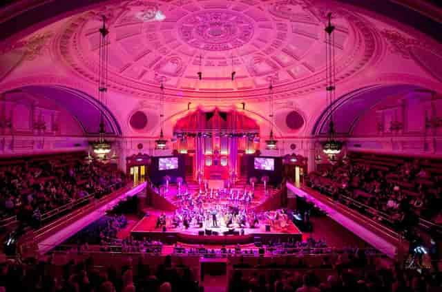 Convention center in Westminster with vibrant pink lighting for a live concert event.