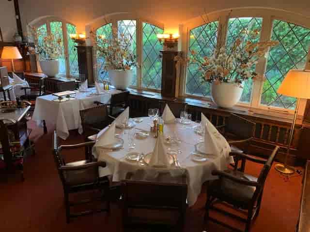 Old Dutch banquet hall with round tables, ideal for upscale wedding receptions and formal events.