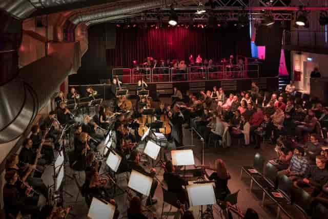 Technikum industrial venue hosting an orchestral concert with stage lighting.