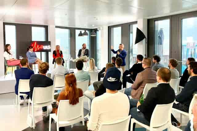 Corporate panel discussion at Raum Scribble, DECK7, featuring modular seating for professional events.